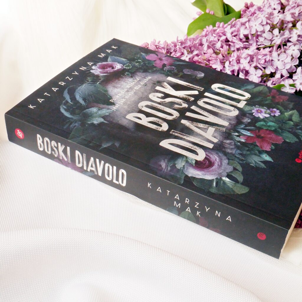 Grzbiet i okładka książki „Boski Diavolo” Katarzyny Mak Grzbiet książki „Boski Diavolo” Katarzyny Mak z kwiatami bzu